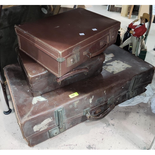 194 - A leather suitcase with old railway labels and 2 smaller suitcases