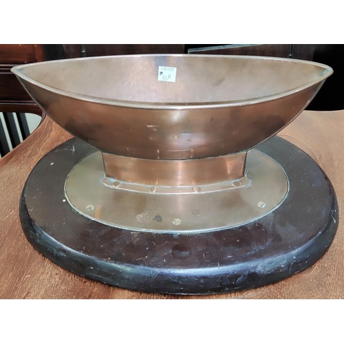 55A - An Arts & Crafts copper table centre in the form of a boat, on a wooden stand, Length 33cm