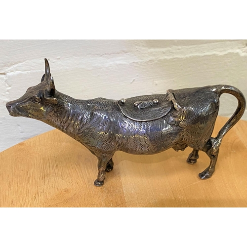 660A - A white metal cow creamer with fly design to back of hinged lid, marked 925, 6.4oz