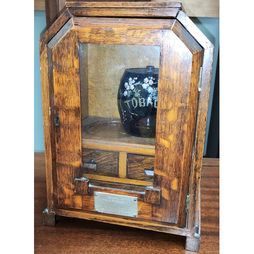 60 - An Art Deco oak cased smokers cabinet with plaque with ceramic tobacco jar
