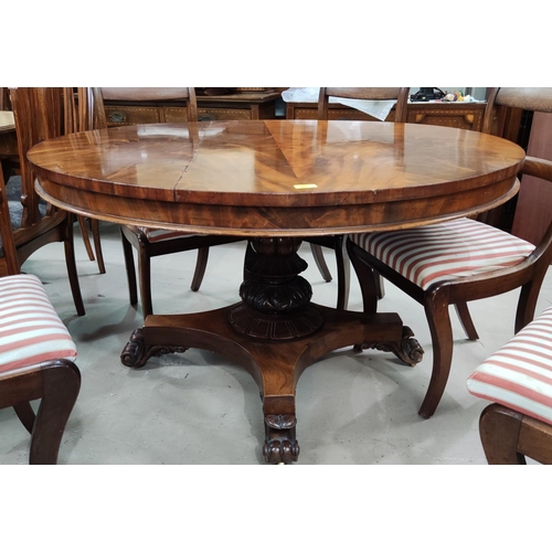 873 - An early 19th century circular figured mahogany tilt top supper table on turned and carved baluster ... 