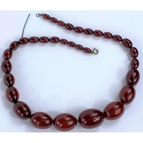656 - A string of 32 cherry amber bakelite graduating beads, from 1cm to 3cm, with internal streaking, 85.... 