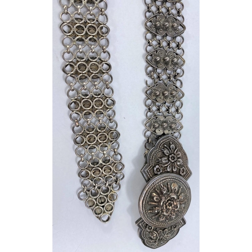 626 - An oriental white metal (silver) belt with chain links and scroll work decoration, can be fastened t... 