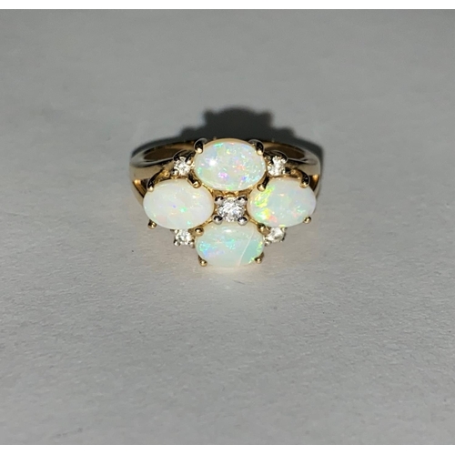 631 - A 9 carat hall marked gold ring set with 4 opal coloured stones and 5 diamond simulants 4.5cm