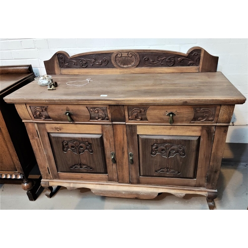 862 - An Edwardian sideboard in stripped and refinished  carved walnut, comprising 2 cupboards and 2 ... 
