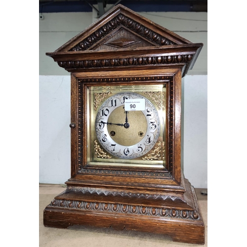 90 - An Edwardian mantel clock in architectural oak case, with striking movement