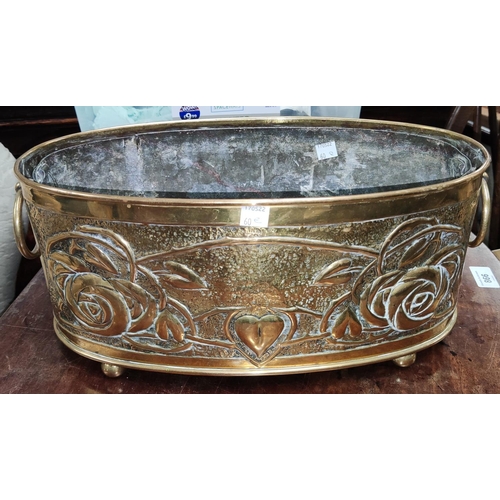 60E - A brass oval planter in the Arts and Crafts manner with Macintosh style roses, double handles length... 
