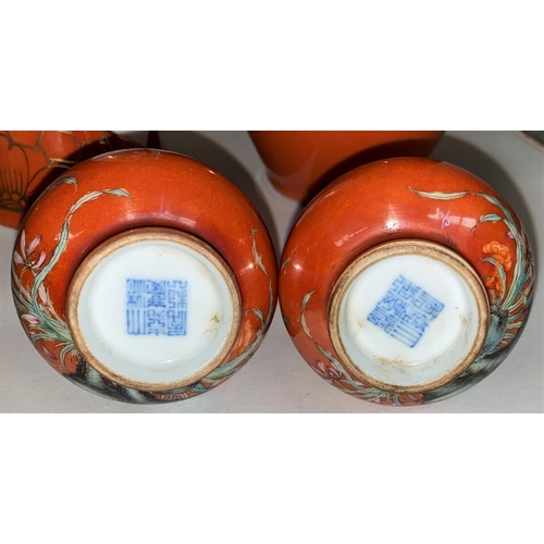 426 - A pair of small Chinese vases of compressed baluster form, naturalistic decoration on orange lustre ... 
