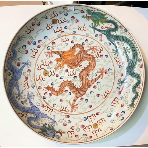 405D - A large Chinese charger decorated with central orange dragon, with other dragons to the border in bl... 