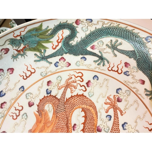 405D - A large Chinese charger decorated with central orange dragon, with other dragons to the border in bl... 