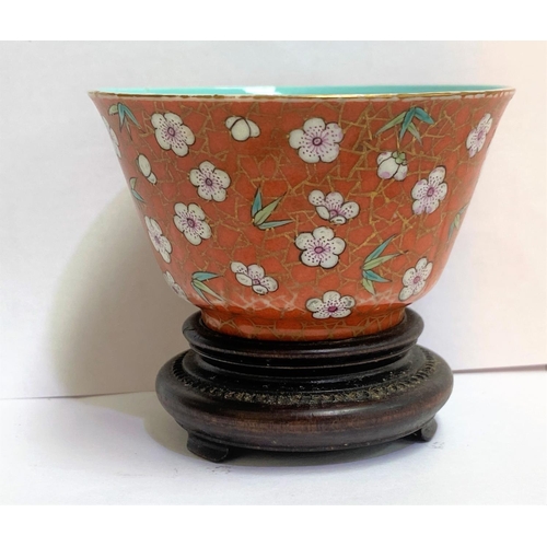 421 - A Chinese porcelain tea bowl in red glaze with flowers on gilt lattice, seal mark to base, 4cm (some... 