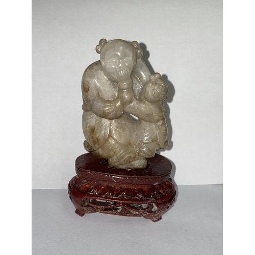 424 - A Chinese carved jade figure of mother and child, 64mm, with stand (good condition)
