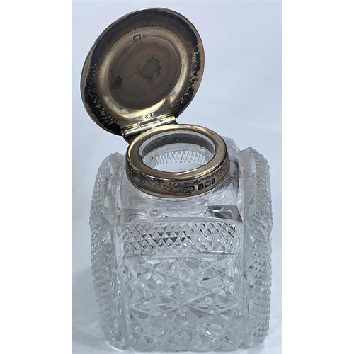 725 - A pair of cut glass inkwells with hallmarked silver lids, Sheffield 1903; a white metal galleon ship