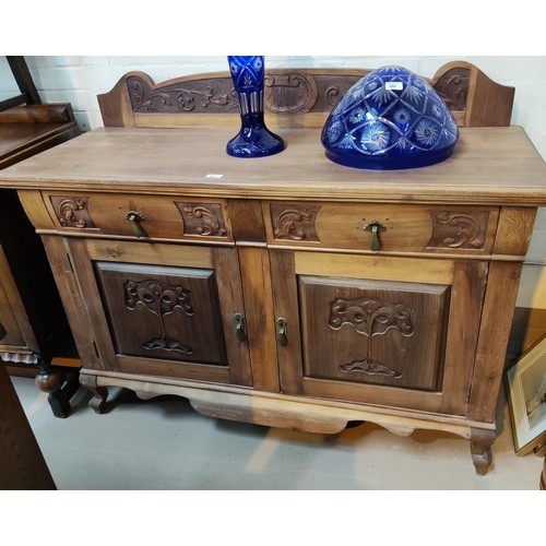 862 - An Edwardian sideboard in stripped and refinished  carved walnut, comprising 2 cupboards and 2 ... 