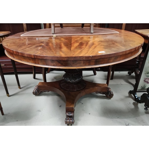 873 - An early 19th century circular figured mahogany tilt top supper table on turned and carved baluster ... 