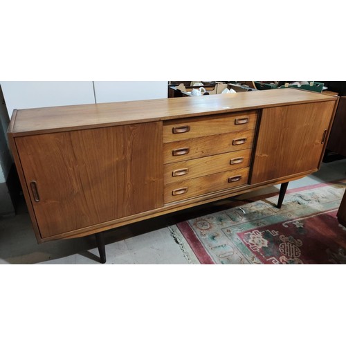 901A - A Danish mid 20th century teak lowline sideboard of 2 side cupboards and 4 central drawers