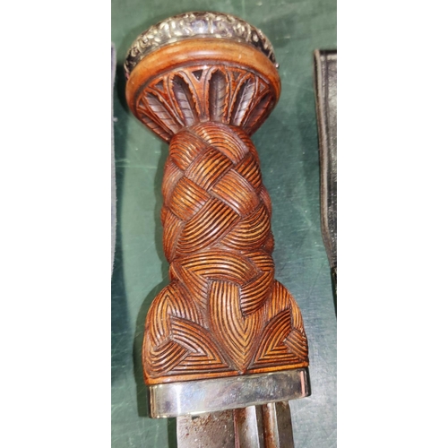 307 - A large Scottish Dirk with plait carved wood handle, white metal mount, 41cm overall