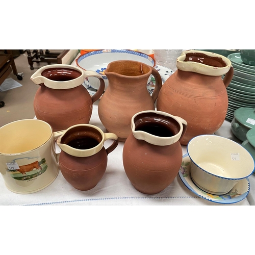 579 - A set of four Victorian graduating terracotta slipware jugs ;a similar Crown Devon bowl and dish; a ... 