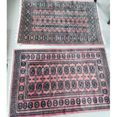 915 - Two rust ground Bokhara rugs with central double lines of elephants feet, 145 x 97cm and 149 x 97cm