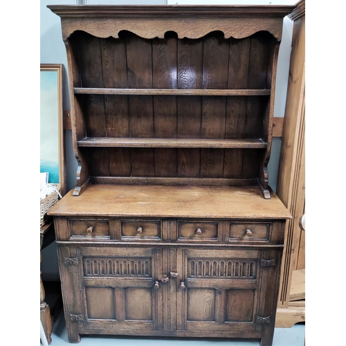 917 - An early 20th century oak dresser with double cupboard and drawers below with two height rack