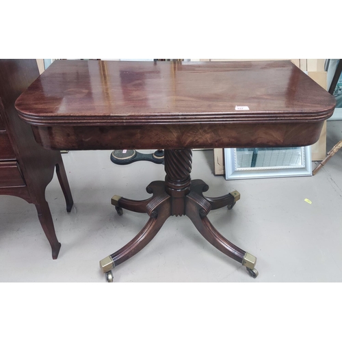 937 - A Georgian mahogany fold over tea table with turned twist column and four reeded splay feet