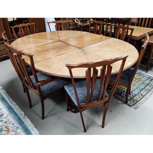 956 - A mid 20th century oriental hardwood dining suite, comprising: a circular extending dining table on ... 