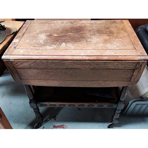 958 - A Jacobean style, oak, drop leaf, two tier Tea Trolley; a rectangular oak coffee table; a pink woven... 