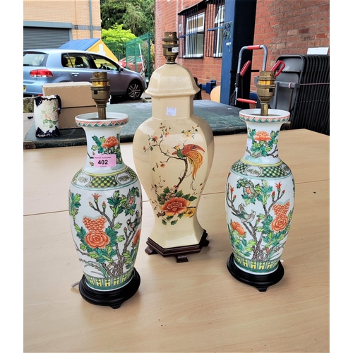 402 - A Chinese pair of porcelain table lamps in the famille verte manner, height 33 cm; and another (a.f.... 