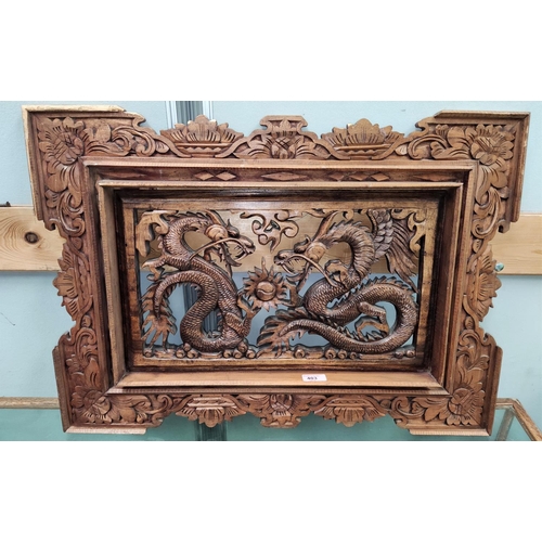 403 - A Chinese carved panel depicting 2 dragons, in stained and pierced wood, 72 x 53 cm
