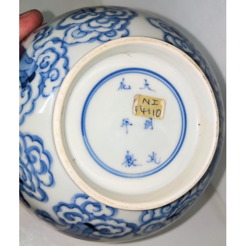 429 - A Chinese ceramic bowl in blue and white decorated with a ring of characters to the outside and deit... 