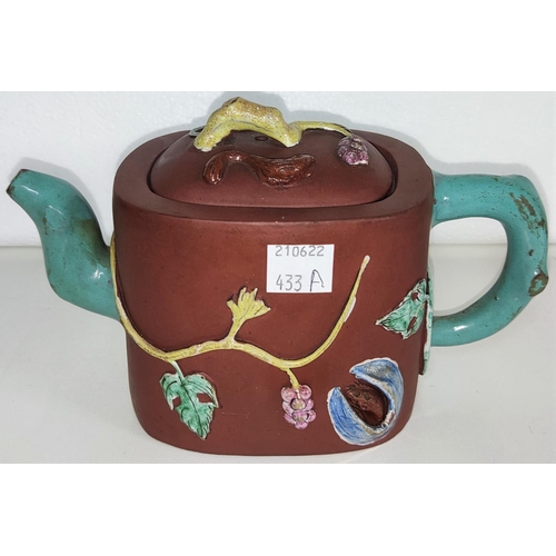 433A - An early 20th century Yixing teapot with coloured handle and spout with relief decoration of leaves ... 