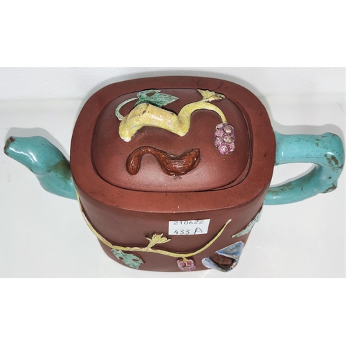 433A - An early 20th century Yixing teapot with coloured handle and spout with relief decoration of leaves ... 