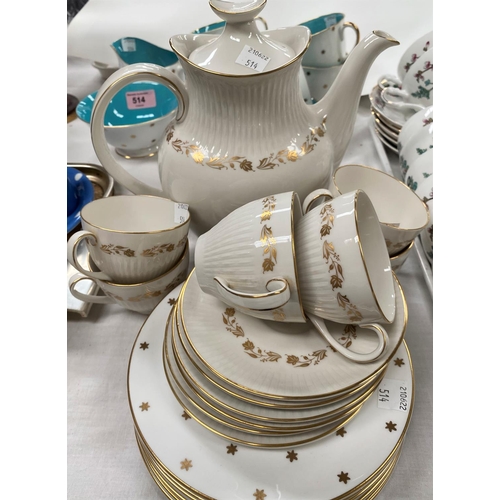 514 - A Susie Cooper part tea service gilt stars turquoise interior, 6 cups and saucers, milk jug and bowl... 