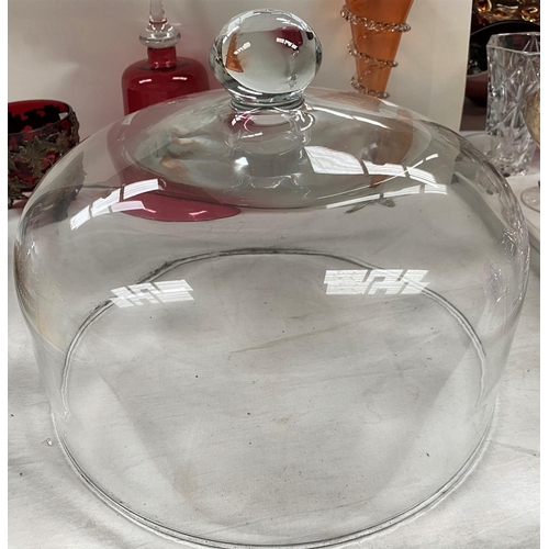 523 - A large circular glass cheese cover, 27cm, a cranberry glass bell, 33cm and 2 other pieces of colour... 