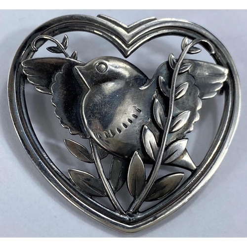588 - Georg Jensen:  a silver  heart shaped pierced brooch with bird, wings outstretched, amongs... 