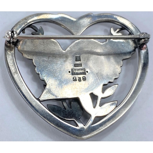 588 - Georg Jensen:  a silver  heart shaped pierced brooch with bird, wings outstretched, amongs... 