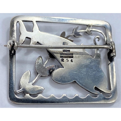 592 - Georg Jensen:  a silver pierced rectangular brooch with twin leaping dolphins and diagonal frond, de... 