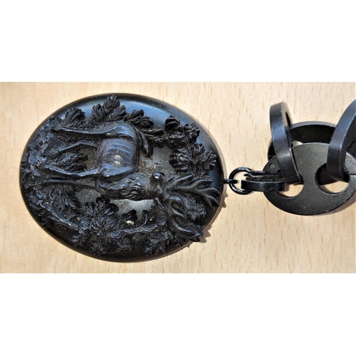 600 - A late 19th/early 20th century mourning locket carved with a stag in woodland setting, on long link ... 