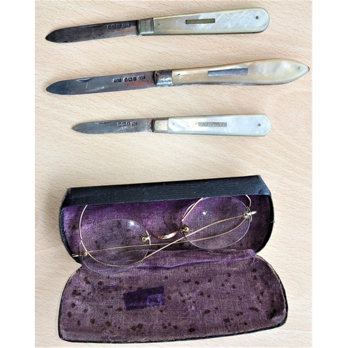 602 - Three hallmarked silver and mother-of-pearl fruit knives; a gilt pair of vintage spectacles
