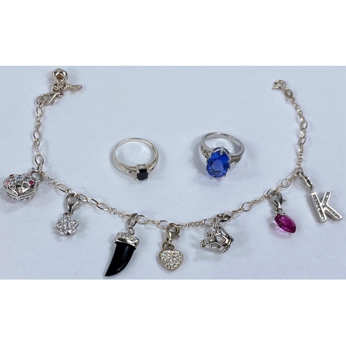 629 - A white metal charm bracelet with charms stamped '925'; 2 white metal stone set dress rings stamped ... 