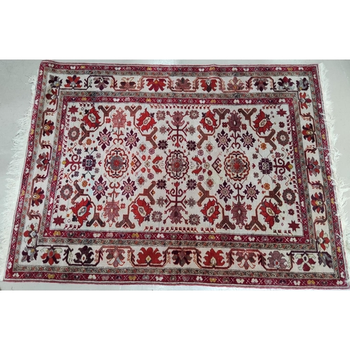 823 - A Persian hand knotted rug with ivory ground and red highlights