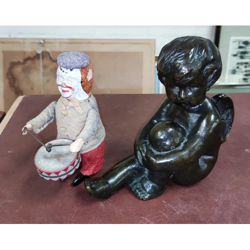 55A - A bronze figure of a cherub seated, a vintage Shuco figure and a wind up drumming clown