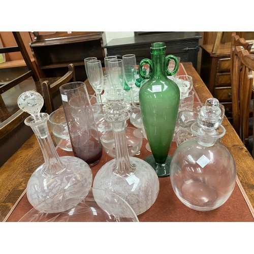 544A - An unusual green glass vase with double handles and tapering shape; two etched decanters and another... 