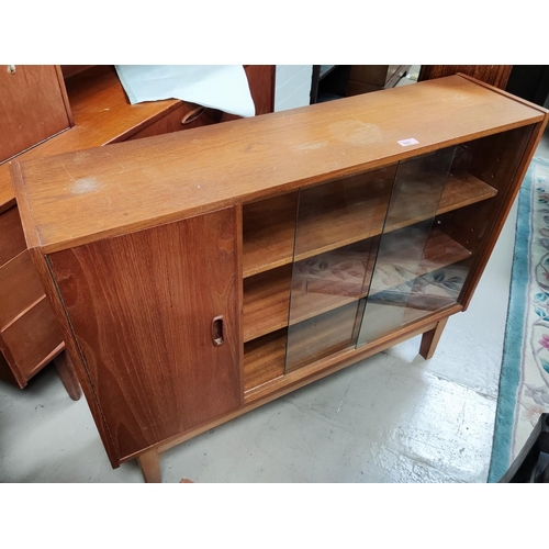 923 - A mid 20th century teak bookcase with sliding glass doors and single cupboard, 106cm