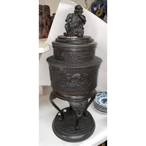 424 - A Japanese bronze Koro of cylindrical form, the top with mythical figure on tripod support with circ... 