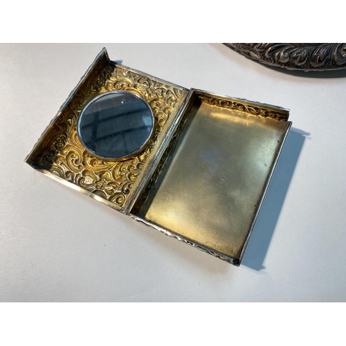 618 - A silver rectangular compact with repousse scrollwork decoration, Birmingham 1902 and a silver cased... 