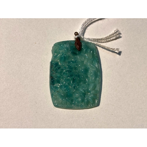 622 - A turquoise jade coloured rectangular pendant in the Chinese manner, with relief decoration of flowe... 