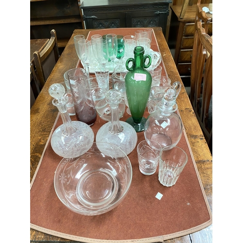 544A - An unusual green glass vase with double handles and tapering shape; two etched decanters and another... 