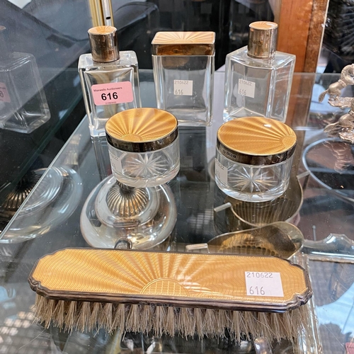 616 - A pair of art deco silver mounted scent bottles, three matching jars and a clothes brush, all decora... 
