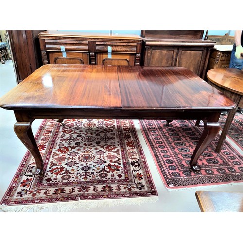 828 - An early 20th century mahogany wind out dining table, 2 spare leaves